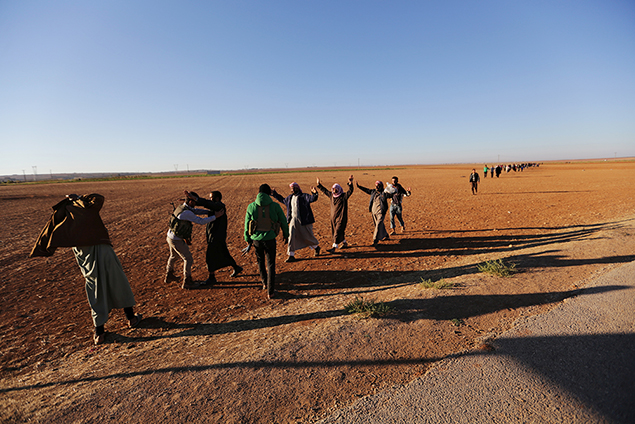 Rebel fighters search men who fled from Islamic State-controlled areas, upon their arrival in the northern Syrian rebel-held town of Waqf, near al-Rai town, in Aleppo Governorate, Syria, September 29, 2016. (Reuters)