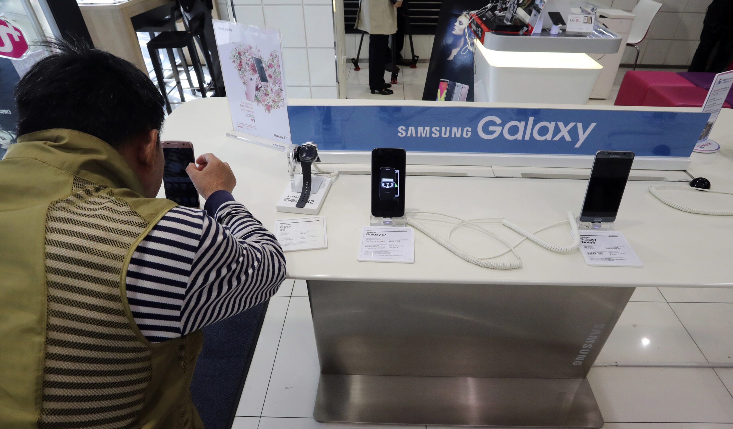 A visitor tries the Samsung Electronics' S7 edge smartphone at a shop of South Korean mobile carrier in Seoul, South Korea, Thursday, Oct. 13, 2016. Samsung Electronics says it has expanded its recall of Galaxy Note 7 smartphones in the U.S. to include all replacement devices the company offered as a presumed safe alternative after the original Note 7s were found prone to catch fire. (AP Photo/Lee Jin-man) (AP)