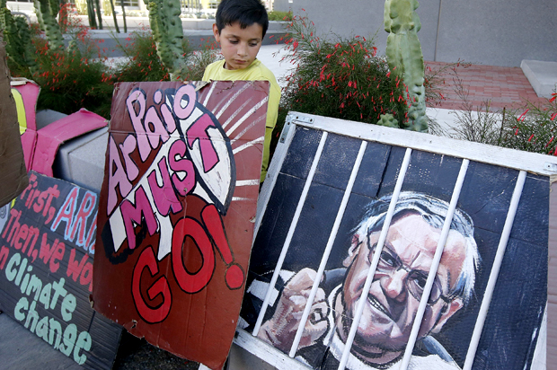 A protester stands with his sign during a rally in front of the Maricopa County Sheriff's Office Headquarters (AP/Ross D. Franklin)