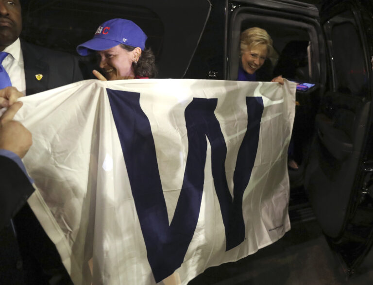 Democratic presidential candidate Hillary Clinton holds a 'W' banner as the Chicago Cubs win the World Series baseball Game 7 against the Cleveland Indians after her final campaign rally of the day at Arizona State University in Tempe, Ariz., Wednesday, Nov. 2, 2016. (AP Photo/Andrew Harnik) (AP)