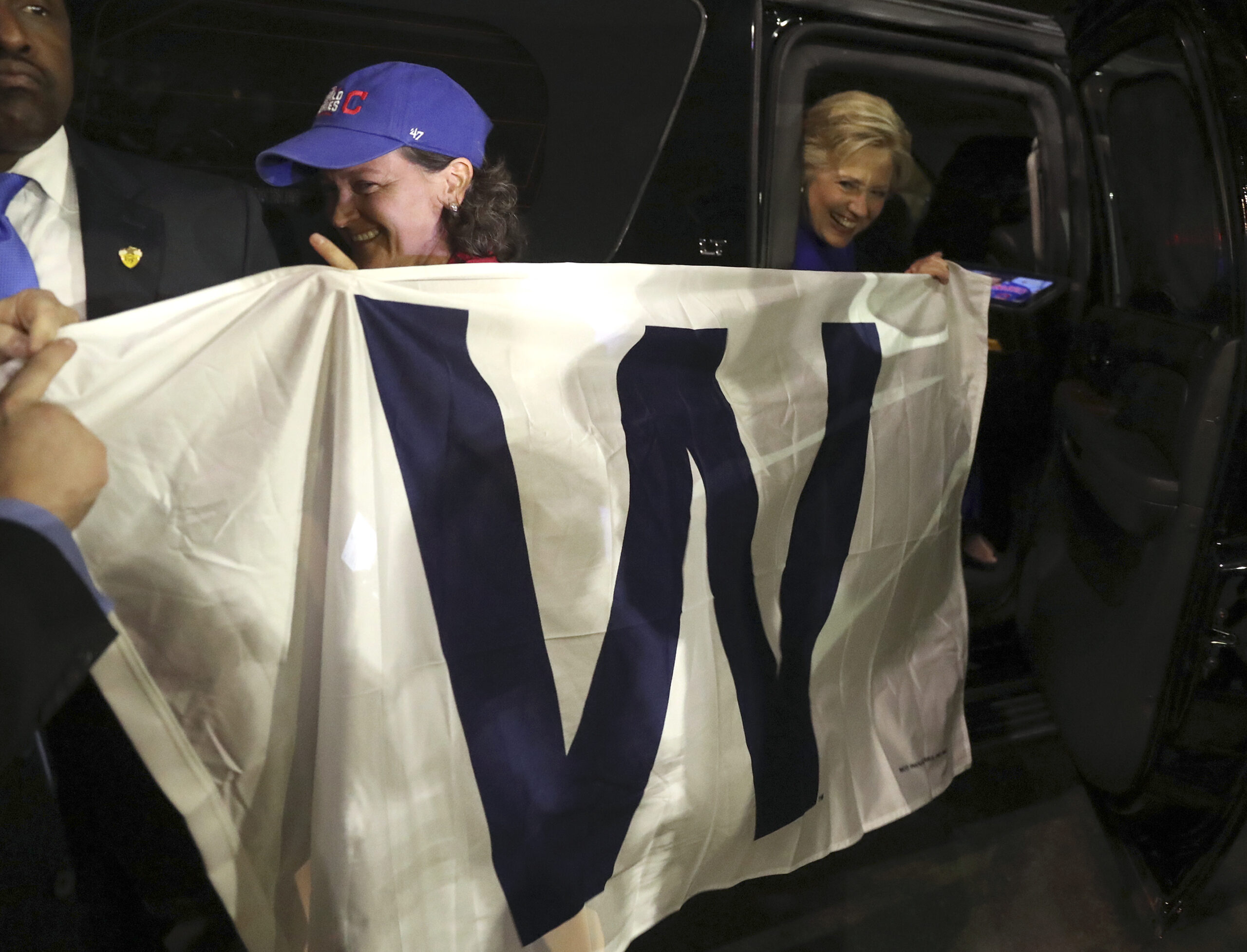 Democratic presidential candidate Hillary Clinton holds a 'W' banner as the Chicago Cubs win the World Series baseball Game 7 against the Cleveland Indians after her final campaign rally of the day at Arizona State University in Tempe, Ariz., Wednesday, Nov. 2, 2016. (AP Photo/Andrew Harnik) (AP)
