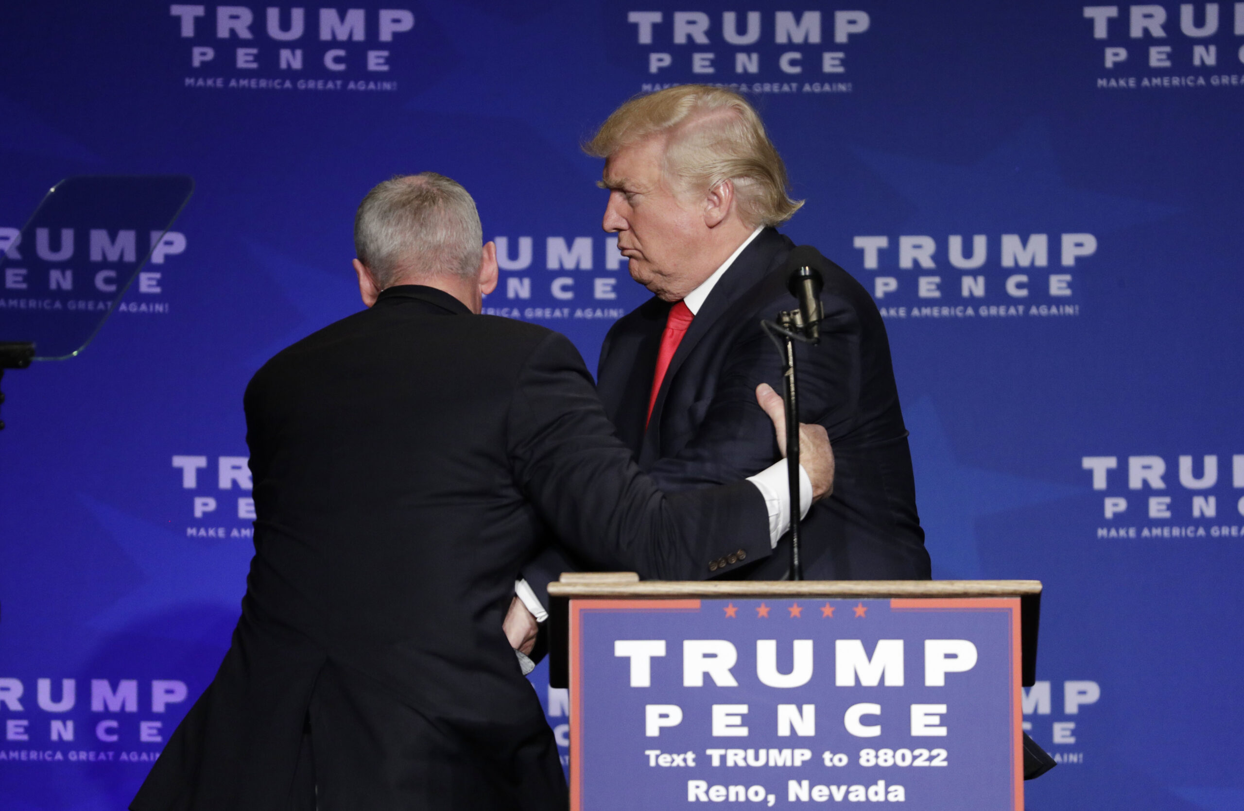 Members of the Secret Service rush Republican presidential candidate Donald Trump off the stage at a campaign rally in Reno, Nev., on Saturday, Nov. 5, 2016. (AP Photo/John Locher) (AP Photo/John Locher)
