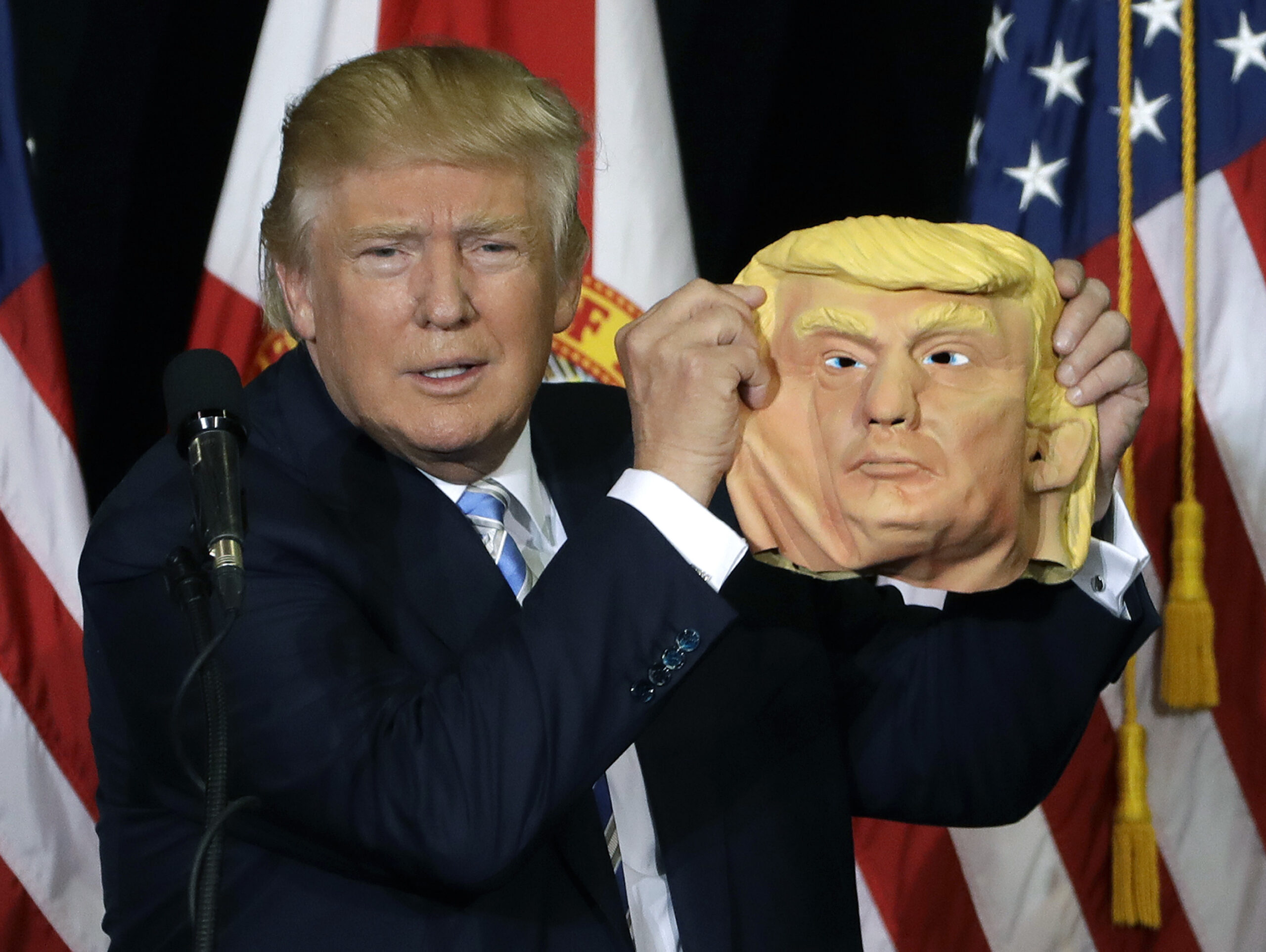 Republican presidential candidate Donald Trump holds up a Donald Trump mask during a campaign speech, Monday, Nov. 7, 2016, in Sarasota, Fla. (AP)