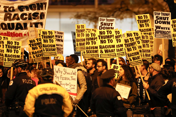 Protesters hold signs during a protest against Republican president-elect Donald Trump in Chicago (Reuters/Kamil Krzacznski)