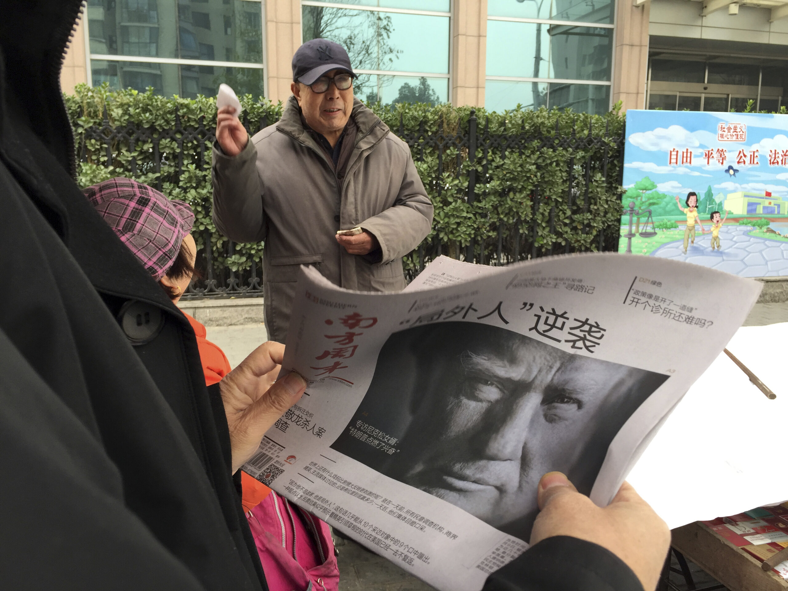 A Chinese man holds up a Chinese newspaper with the front page photo of U.S. President-elect Donald Trump and the headline "Outsider counter attack" at a newsstand in Beijing, China, Thursday, Nov. 10, 2016. Trump is a mixed blessing for Chinese leaders. His threats to tear up trade deals and hike tariffs on Chinese goods could chill thriving commercial ties when Beijing is struggling to shore up economic growth. At the same time, Trump’s suggestion he might reduce Washington’s global strategic presence to focus on domestic issues would be a gift to Chinese leaders. They could expand their political and military profile in East Asia with less risk of conflict. () (AP Photo/Ng Han Guan)