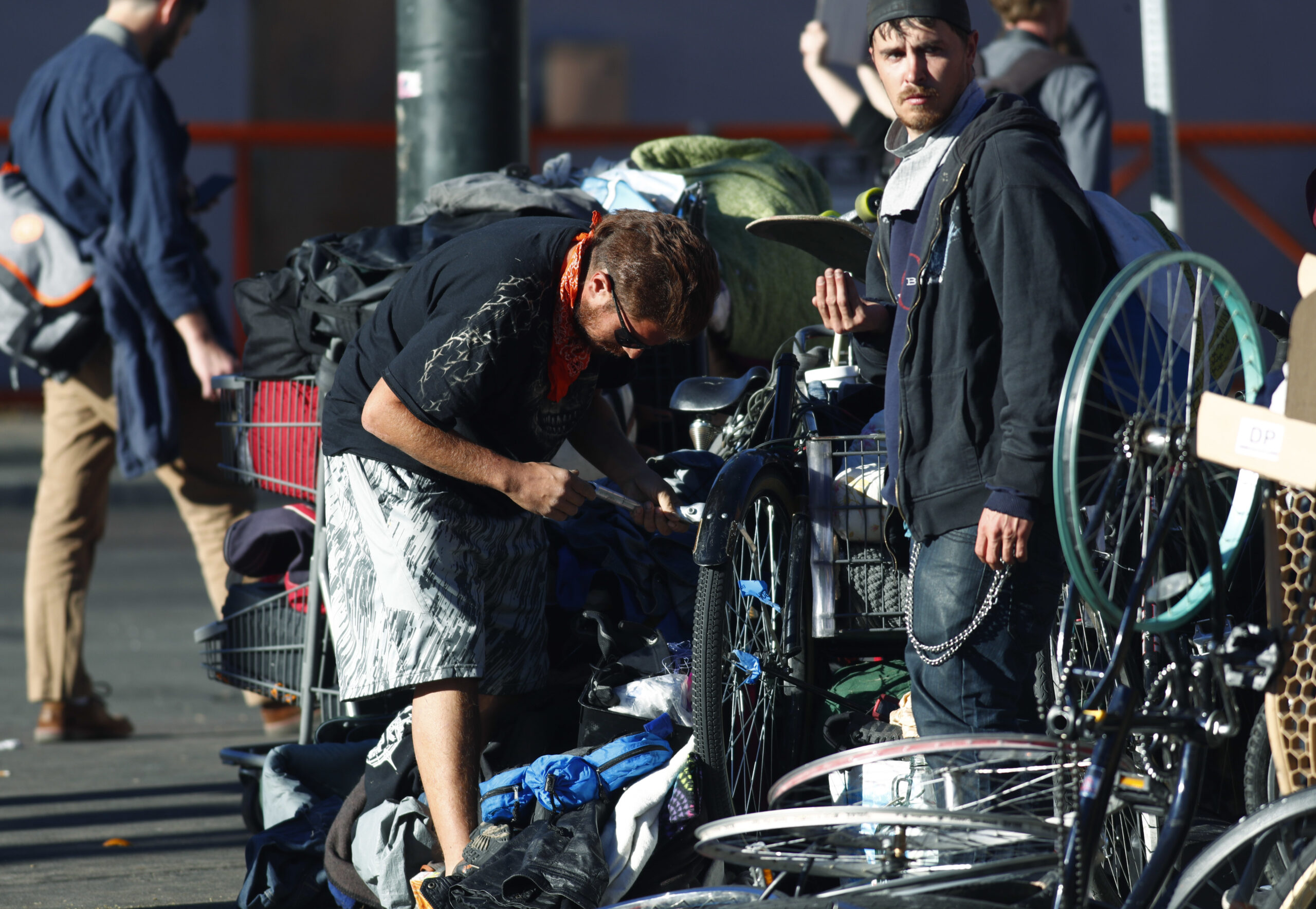Unidentified men pack up their belongings during a sweep of homeless people who were living on the walks surrounding a shelter near the baseball stadium Tuesday, Nov. 15, 2016, in downtown Denver.  new report from The National Law Center on Homelessness and Poverty said Tuesday, Nov. 15, 2016, that cities nationwide such as Denver are enacting more policies that criminalize homelessness. (AP Photo/David Zalubowski) (AP)