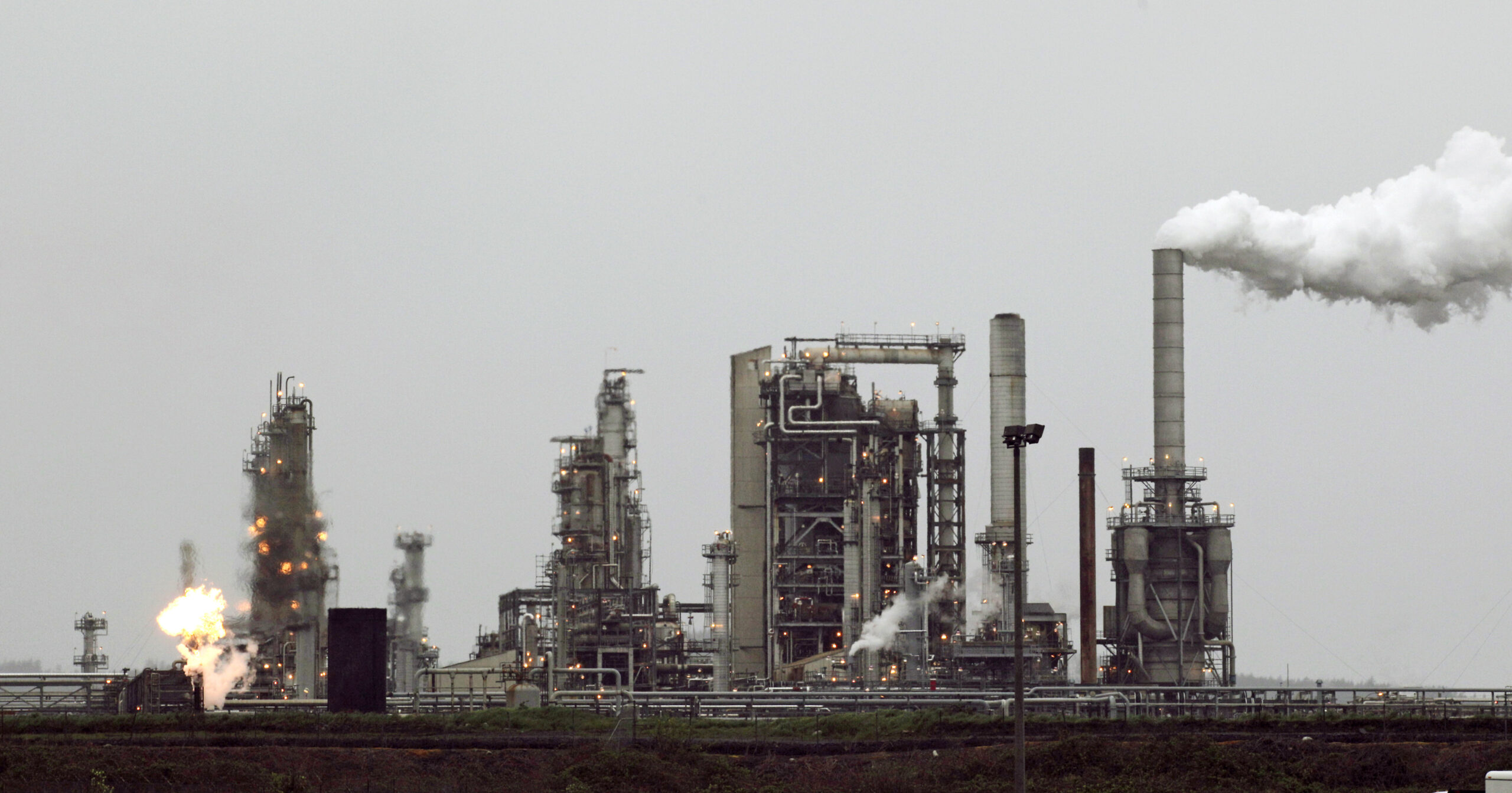 FILE - This April 2, 2010 file photo shows a Tesoro Corp. refinery, including a gas flare flame that is part of normal plant operations, in Anacortes, Wash. In the 2016 election, voters in Washington state rejected an initiative that would have taxed carbon emissions from fossil fuels such as coal and gasoline. () (AP Photo/Ted S. Warren, File)