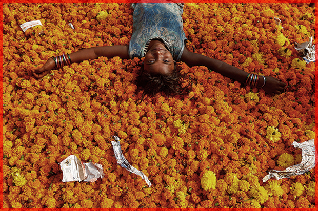 A girl plays on a pile of discarded flowers outside a market, the day after the Diwali celebrations in Mumbai, India October 31, 2016. REUTERS/Shailesh Andrade - RTX2R7MP (Reuters)