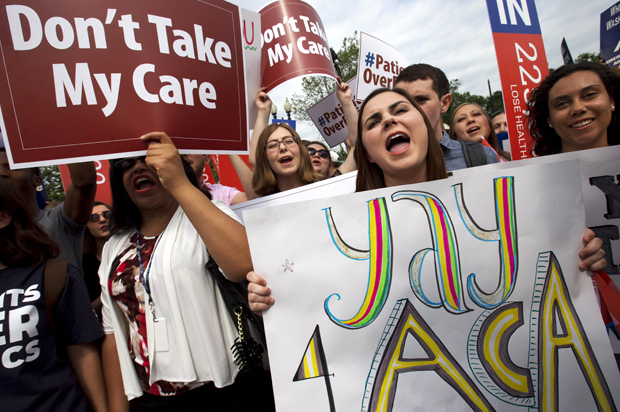 Supporters of the Affordable Care Act react with cheers as the opinion for health care is reported outside of the Supreme Court in Washington (AP/Jacquelyn Martin)