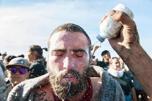 A person pours a pepper spray antidote into a protester's eyes during a protest against the building of a pipeline on the Standing Rock Indian Reservation near Cannonball, North Dakota. (Reuters)