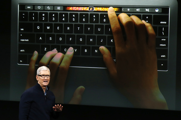 Tim Cook speaks under a graphic of the new MacBook Pro at an Apple media event in Cupertino, California, October 27, 2016. (Reuters/Beck Diefenbach)