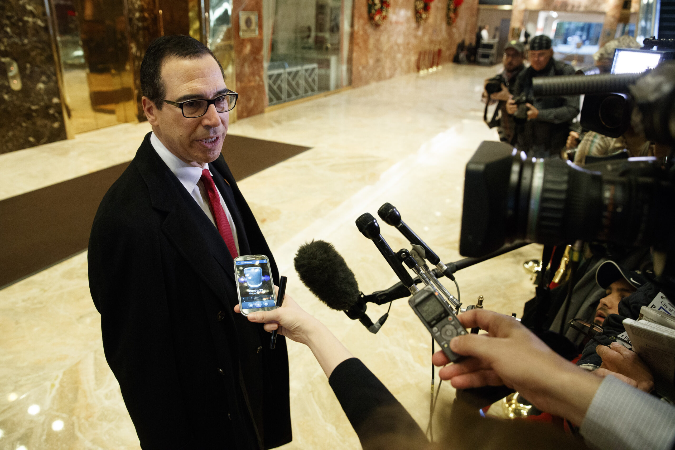 Steven Mnuchin, President-elect Donald Trump's nominee for Treasury Secretary, talks with reporters in the lobby of Trump Tower. (AP)