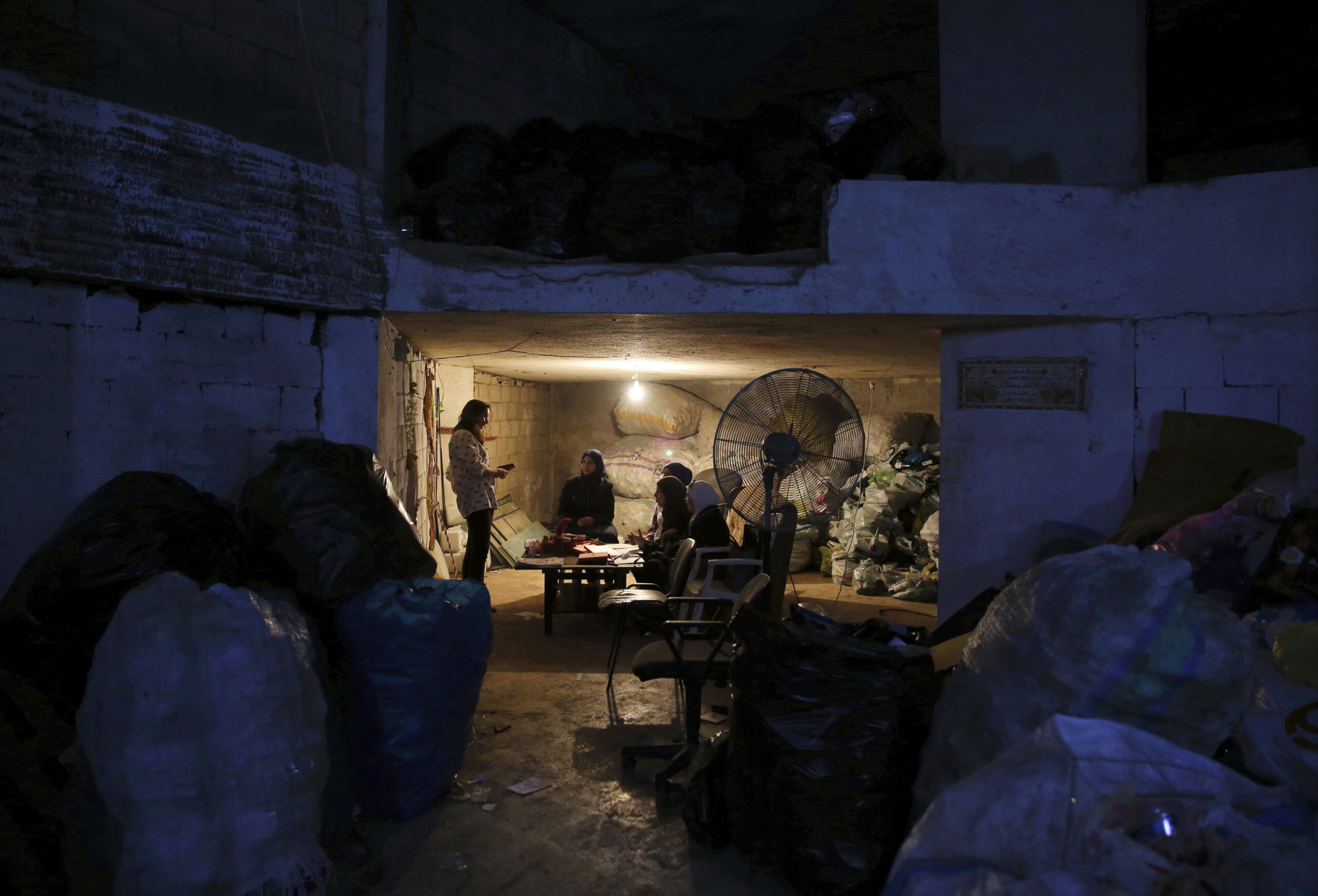 In this Friday, Oct. 28, 2016 photo, Syrian refugee Haela Kalawi, 31, second left, and fellow Syrian refugees sit on a sofa surrounded by the garbage as they attend an English class at Recycle Beirut, their work place in Ouzai, a poor neighborhood in the Lebanese capital of Beirut. About one-third of 240,000 Syrian refugee households in Lebanon are headed by women, in stark contrast to Syria's traditions which see men as providers and protectors. The husbands of the women surviving on their own are either dead, missing, chose to remain in Syria or tried to make their way to Europe. (AP Photo/Bilal Hussein) (AP)