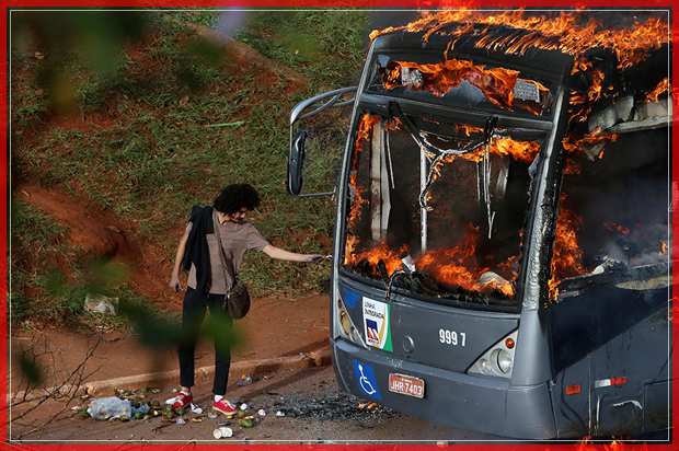 A man lights up his cigarette with the flames of a bus burned by anti-government demonstrators during a protest against the constitutional amendment PEC 55, which limits public spending, in front of Brazil's National Congress in Brasilia, Brazil December 13, 2016. REUTERS/Adriano Machado      TPX IMAGES OF THE DAY - RTX2UWP3 (Reuters)