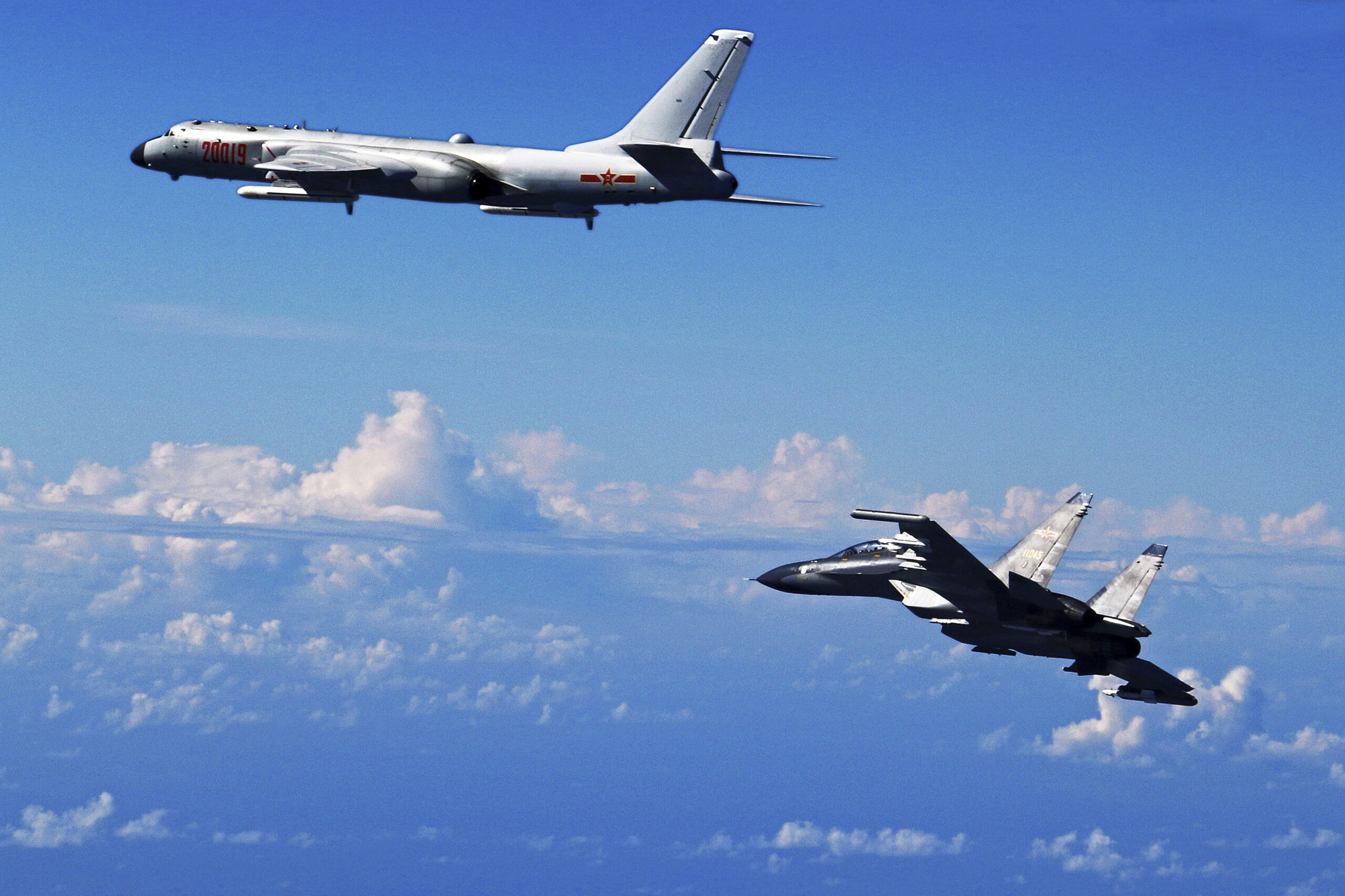 FILE - In this Sept. 25, 2016 file photo released by Xinhua News Agency, Chinese People's Liberation Army Air Force Su-30 fighter, right, flies along with a H-6K bomber as they take part in a drill near the East China Sea. China patrolled the waters of a series of hotly contested islands on Sunday, Dec. 11, 2016, a day after staging a flyover of two strategically important waterways near Taiwan and Japan. (AP)