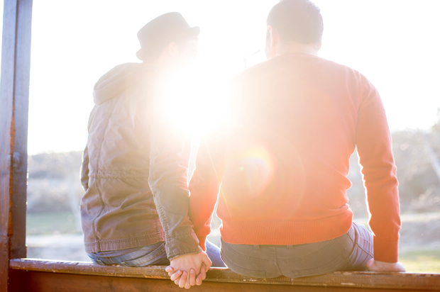 Gay couple sitting in a meadow enjoying the view (Getty/Pekic)