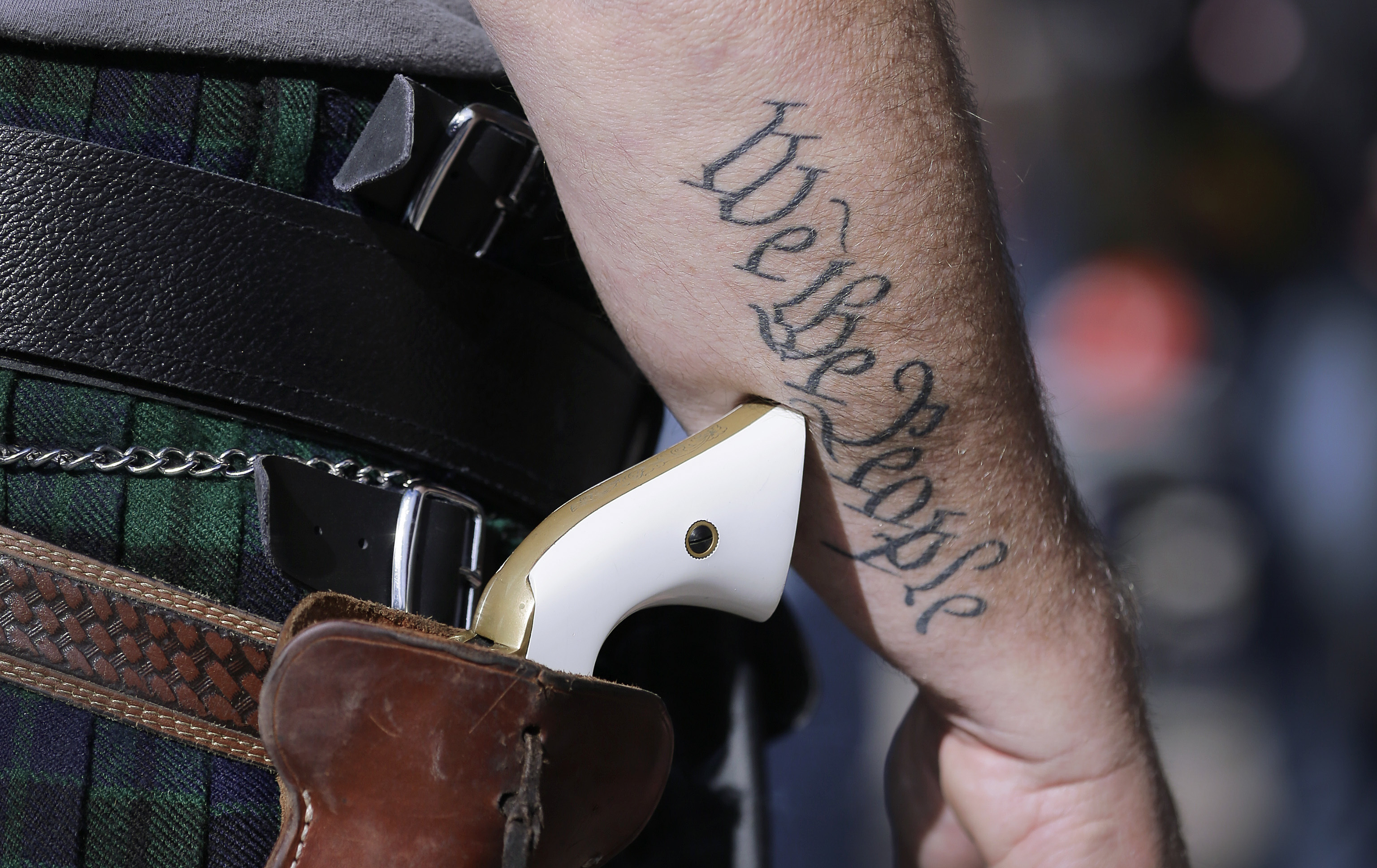 FILE - In this Jan. 26, 2015 file photo, a supporter of open carry gun laws, wears a pistol as he prepares for a rally in support of open carry gun laws at the Capitol, in Austin, Texas. Texas is still sorting out where firearms are allowed, and where they're not, more than a year after Republican Gov. Greg Abbott signed a suite of laws that vastly expanded gun rights. (AP Photo/Eric Gay, File) (AP)