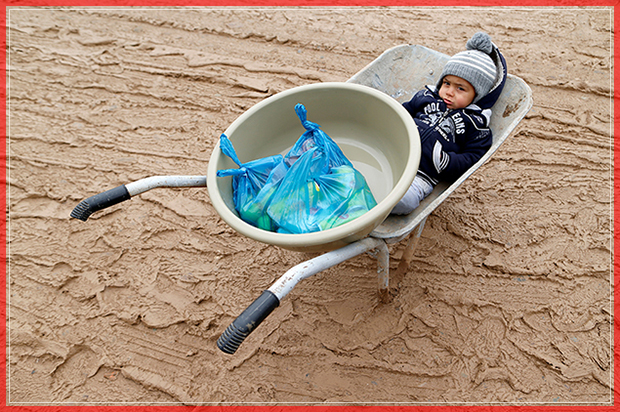 A young displaced Iraqi boy, who fled the Islamic State stronghold of Mosul, sits in a wheelbarrow at Khazer camp, Iraq,December,20, 2016.   REUTERS/Ammar Awad     TPX IMAGES OF THE DAY - RTX2VUWJ (Reuters)