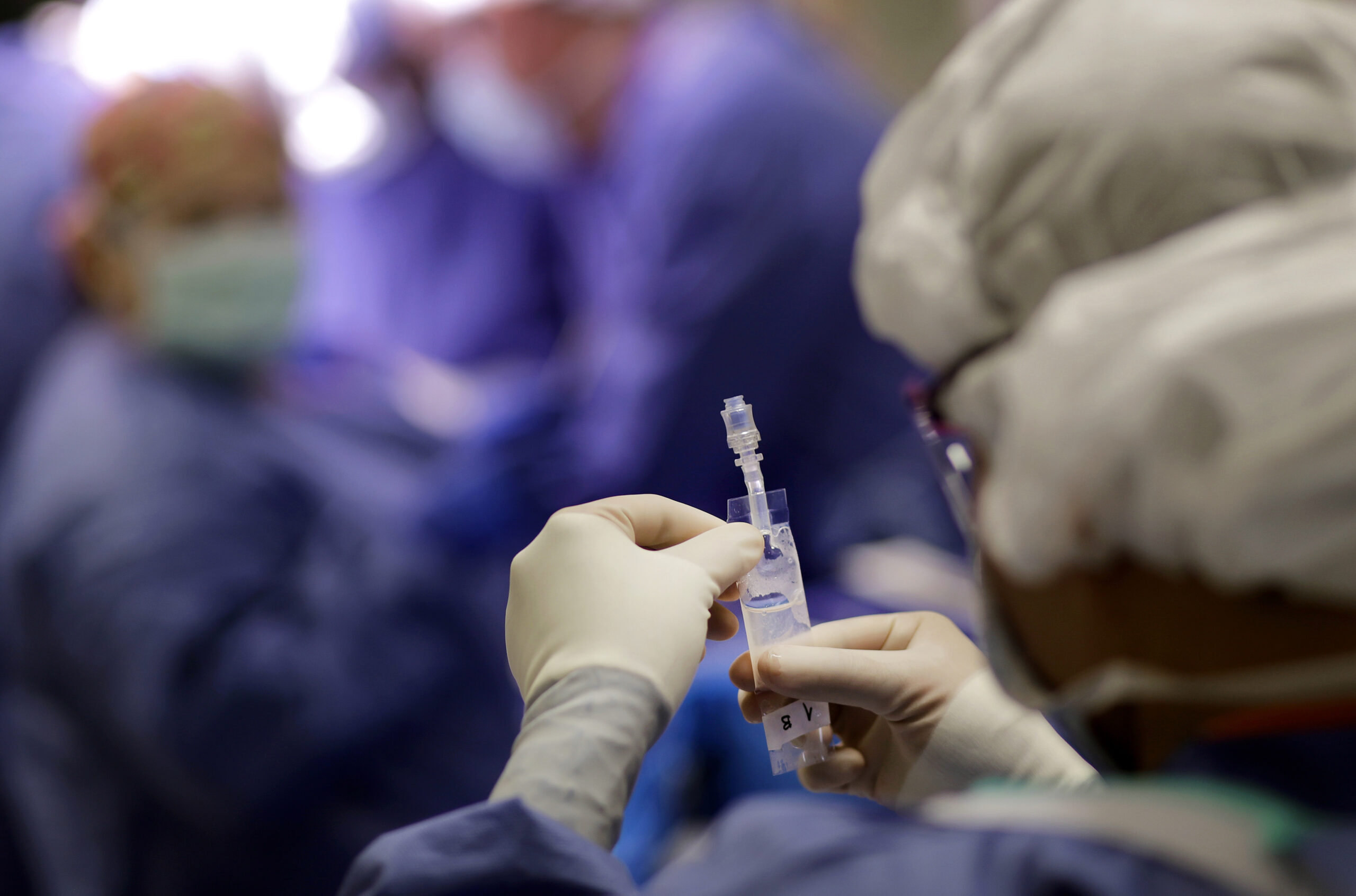 In this Nov. 28, 2016 photo, a researcher inserts stem cells into a syringe before doctors inject them into Josue Salinas Salgado's heart during open heart surgery at the University of Maryland Medical Center in Baltimore. (AP Photo/Patrick Semansky) (AP)