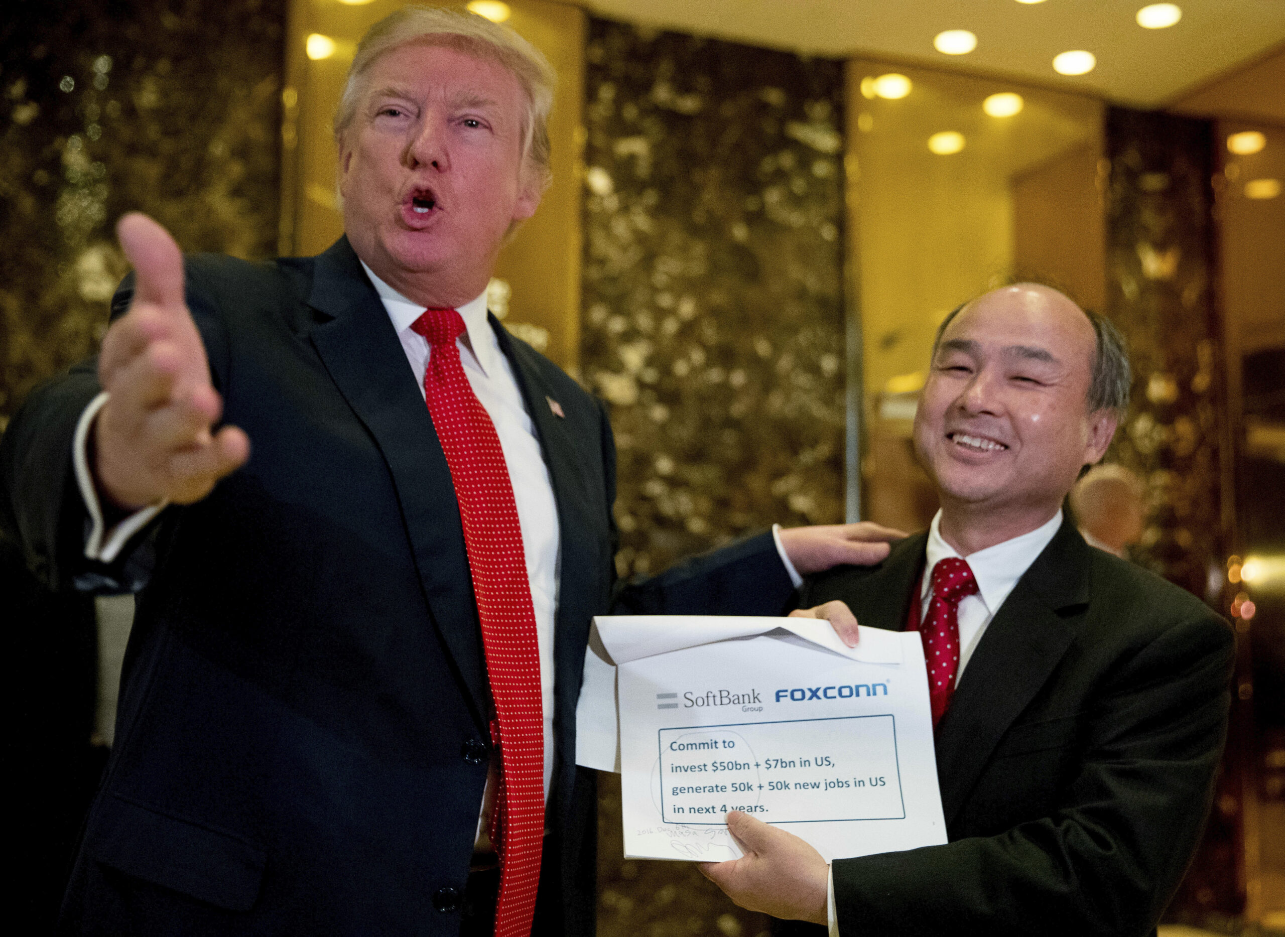 FILE - In this Tuesday, Dec. 6, 2016, file photo, President-elect Donald Trump, left, accompanied by SoftBank CEO Masayoshi Son, speaks to members of the media at Trump Tower in New York. Trump talked up Japanese mogul Son, who after meeting with the president-elect in New York, spotlighted his plan to invest $50 billion and create 50,000 jobs. (AP Photo/Andrew Harnik, File) (AP)