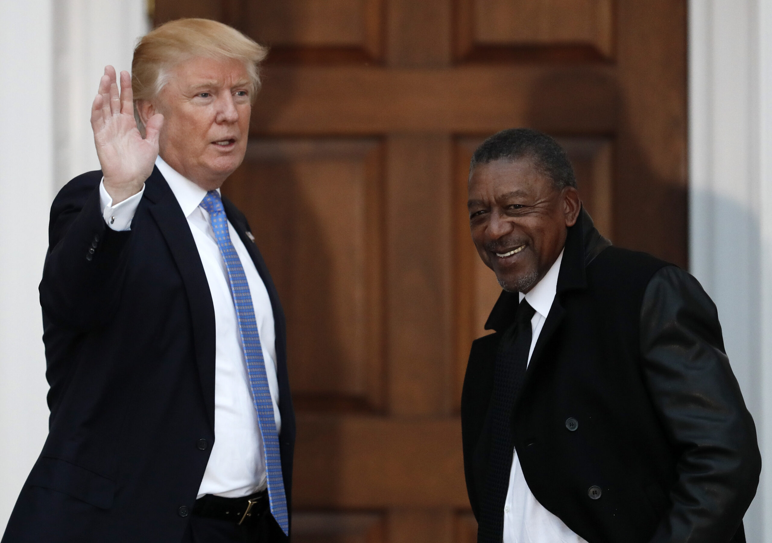 FILE - In this Nov. 20, 2016 file photo, President-elect Donald Trump stands with BET founder Robert Johnson at the Trump National Golf Club Bedminster clubhouse in Bedminster, N.J.. Johnson is one of dozens of people who have paraded into Trump’s properties in New York and New Jersey in recent weeks for job interviews and other consultations with the Republican. Several described the meetings as serious, yet conversational, with the president-elect leading the discussion and asking questions extemporaneously, without consulting notes. (AP Photo/Carolyn Kaster, File) (AP)
