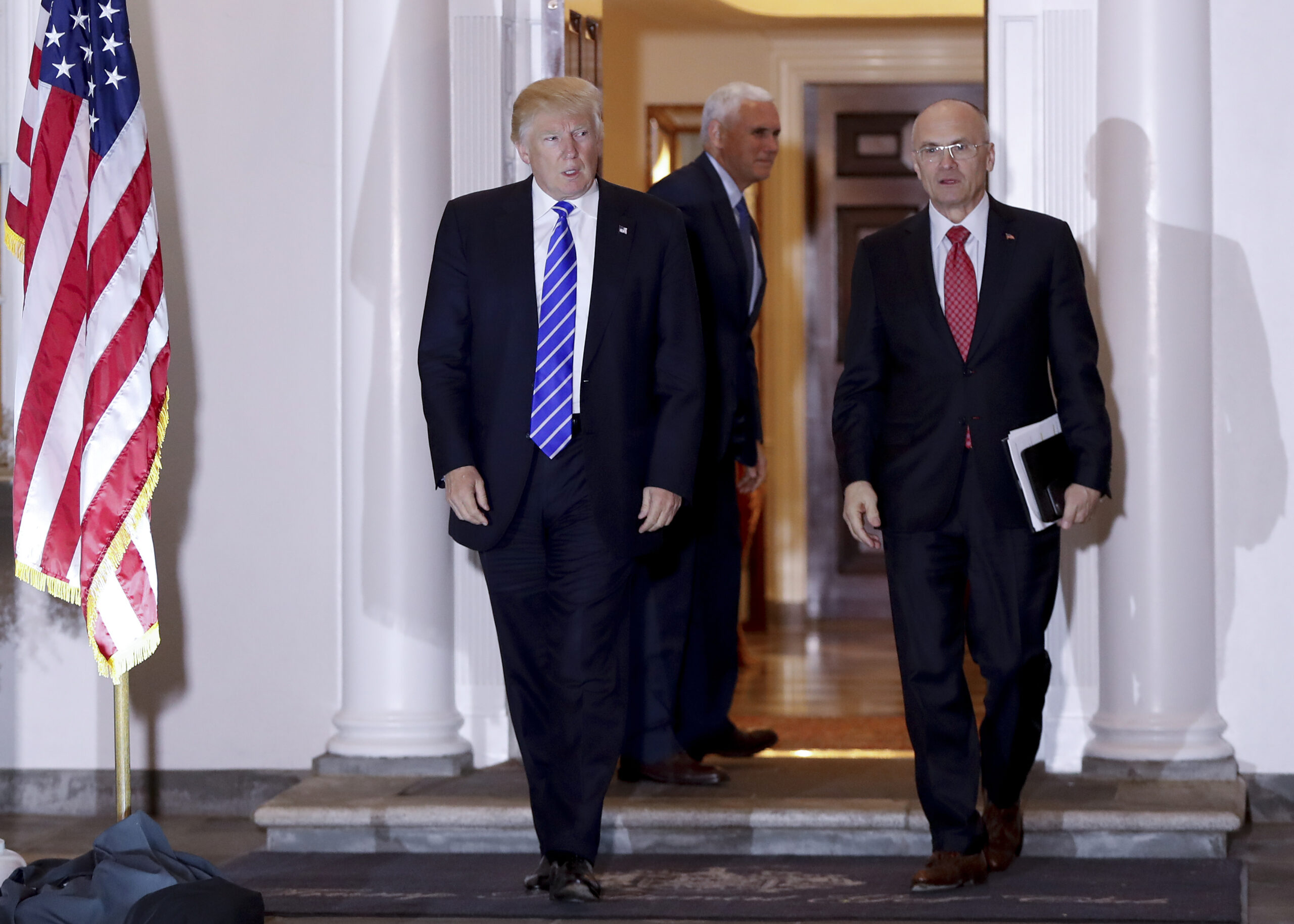 FILE - In this Nov. 19, 2016 file photo, President-elect Donald Trump walks with CKE Restaurants CEO Andy Puzder from Trump National Golf Club Bedminster clubhouse in Bedminster, N.J. Trump is expected to add another wealthy business person and elite donor to his Cabinet, with fast food executive Andrew Puzder as Labor secretary. In the background is Vice President-elect Mike Pence. (AP Photo/Carolyn Kaster) (AP)