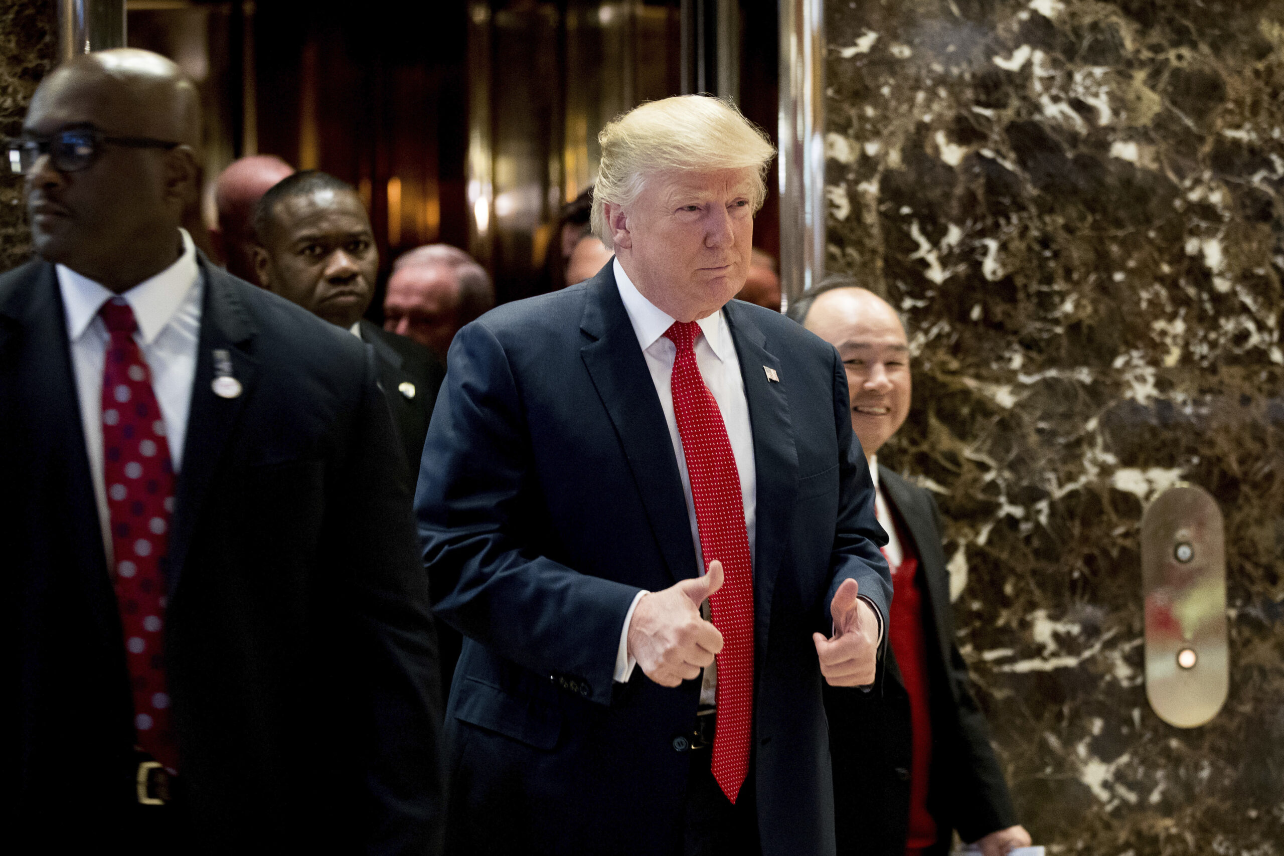 President-elect Donald Trump and SoftBank Chief Executive Officer Masayoshi Son, right, walk into the lobby to speak to members of the media at Trump Tower in New York, Tuesday, Dec. 6, 2016. (AP Photo/Andrew Harnik) (AP)