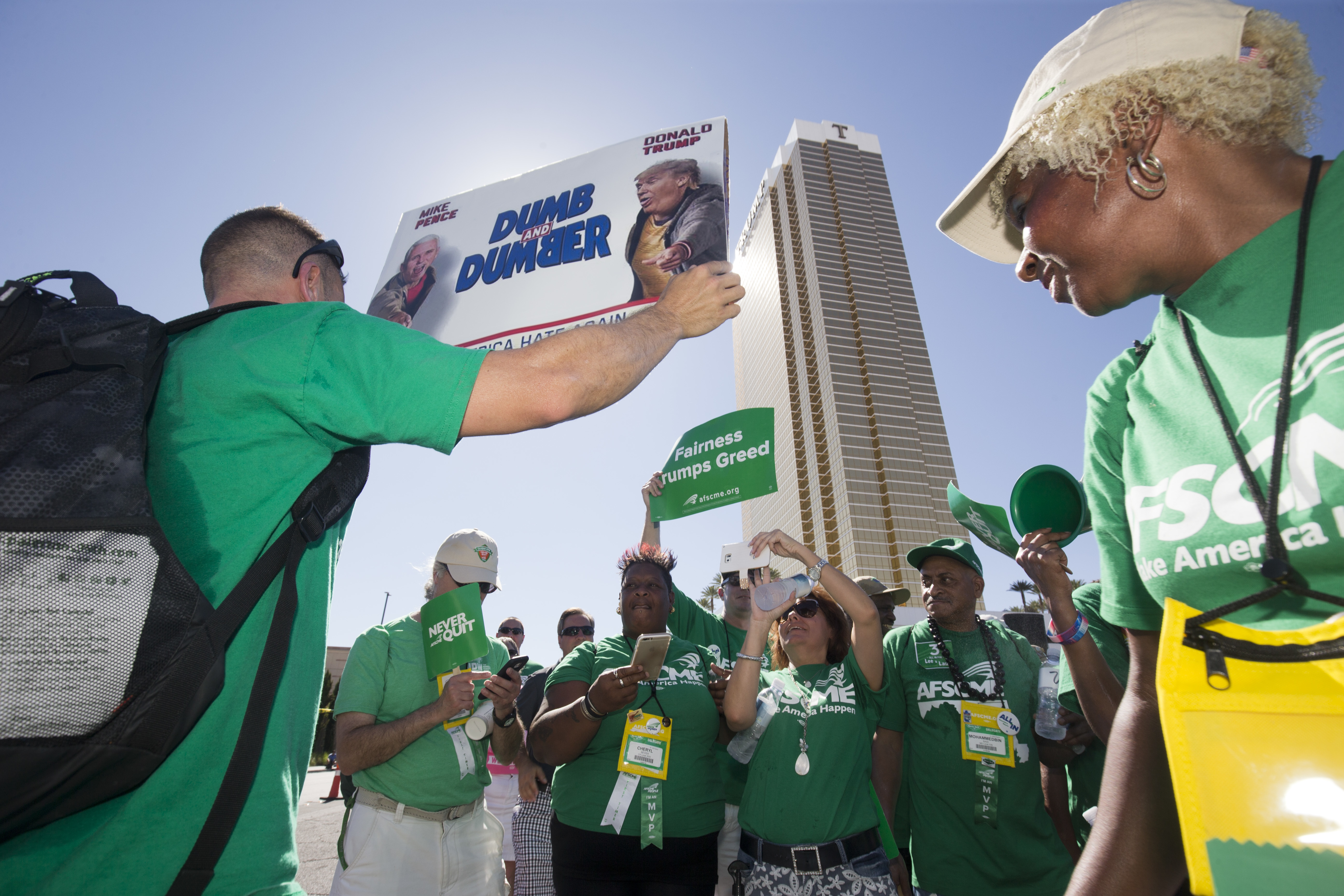 FILE - In this July 20, 2016, file photo, Brian Poncin, of Chicago, a member of the American Federation of State, County and Municipal Employees (AFSCME) union, Local 2858, holds a sign with images of Republican presidential nominee Donald Trump and running mate Indiana Gov. Mike Pence during a rally at the Trump International Hotel Las Vegas in Las Vegas. Union officials announced Wednesday, Dec. 21, 2016, that workers at the Trump International Hotel in Las Vegas reached a contract with management after pushing for negotiations for a year, while management at a Trump hotel in Washington, D.C. has agreed to allow a unionization campaign at that property. (Steve Marcus/Las Vegas Sun via AP, File) (AP)