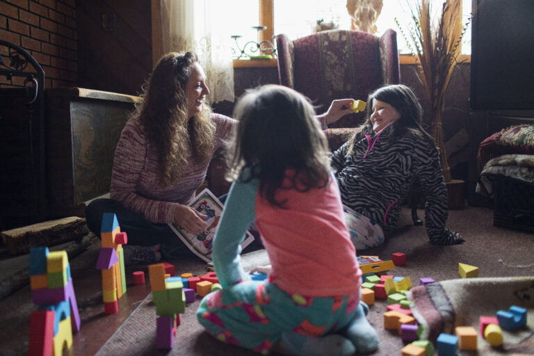 In this Monday, Dec. 19, 2016, photo, Donna Dye, who is unemployed and whose husband is disabled, plays with her two granddaughters, Lilly, left, and Chloe, at her home where she cares for them, in Minnie, Ky. Dye and her husband have been fighting the federal government to keep his Social Security disability checks after a local lawyer who helped them became the subject of a federal fraud investigation. (AP Photo/David Stephenson) (AP)