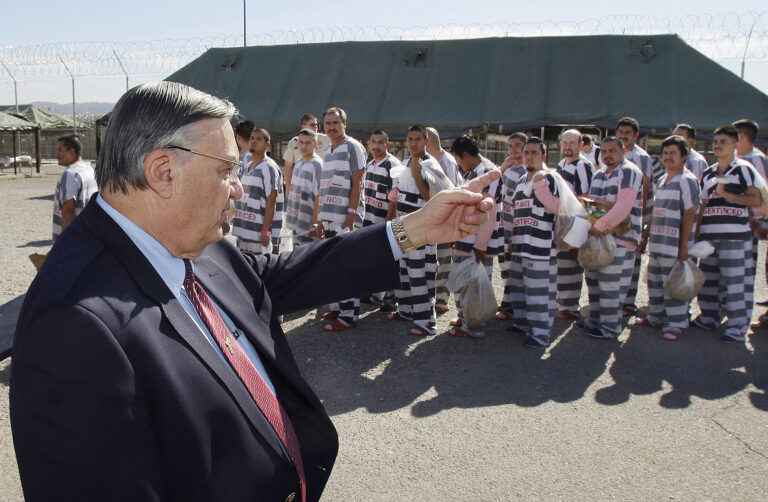 FILE - In this Feb. 4, 2009, file photo, Maricopa County Sheriff Joe Arpaio, left, orders approximately 200 convicted illegal immigrants handcuffed together and moved into a separate area of Tent City, for incarceration until their sentences are served and they are deported to their home countries, in Phoenix. (AP Photo/Ross D. Franklin, File)