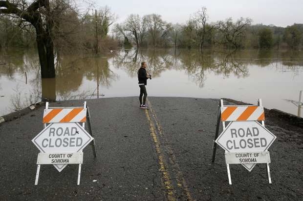 Michelle Wolfe, who had to evacuate her nearby mobile home, looks out toward flooded vineyards in the Russian River Valley, Monday, Jan. 9, 2017, in Forestville, Calif. (AP/Eric Risberg)