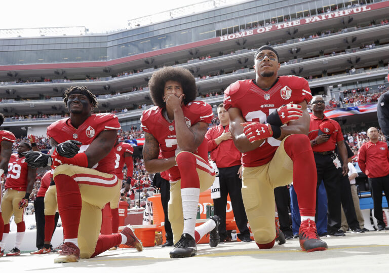 FILE - In this Oct. 2, 2016, file photo, from left, San Francisco 49ers outside linebacker Eli Harold, quarterback Colin Kaepernick and safety Eric Reid kneel during the national anthem before an NFL football game against the Dallas Cowboys in Santa Clara, Calif. During an appearance on Fox News Jan. 3, 2017, former Redskins quarterback Joe Theismann slammed the 49ers' decision to give Kaepernick an award for being an “inspirational and courageous” player. (AP Photo/Marcio Jose Sanchez, File) (AP Photo/Marcio Jose Sanchez, File)