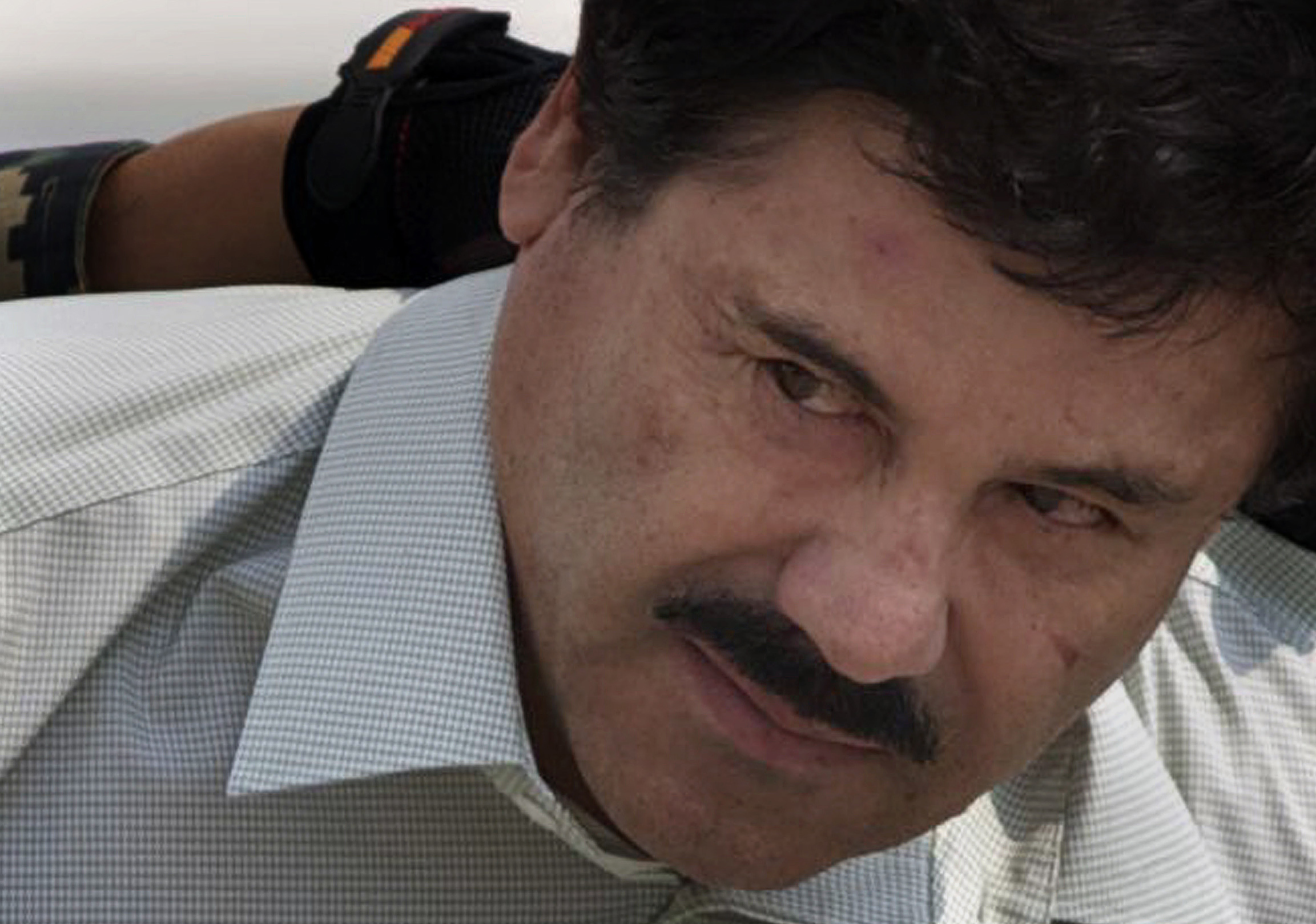 FILE - In this Feb. 22, 2014 file photo, Joaquin "El Chapo" Guzman is escorted to a helicopter in handcuffs by Mexican navy marines at a navy hanger in Mexico City. Mexico's government said on Thursday, Jan. 19, 2017, that it has extradited drug lord Joaquin "El Chapo" Guzman to the U.S. to face drug trafficking and other charges. (AP Photo/Eduardo Verdugo, File) (AP)