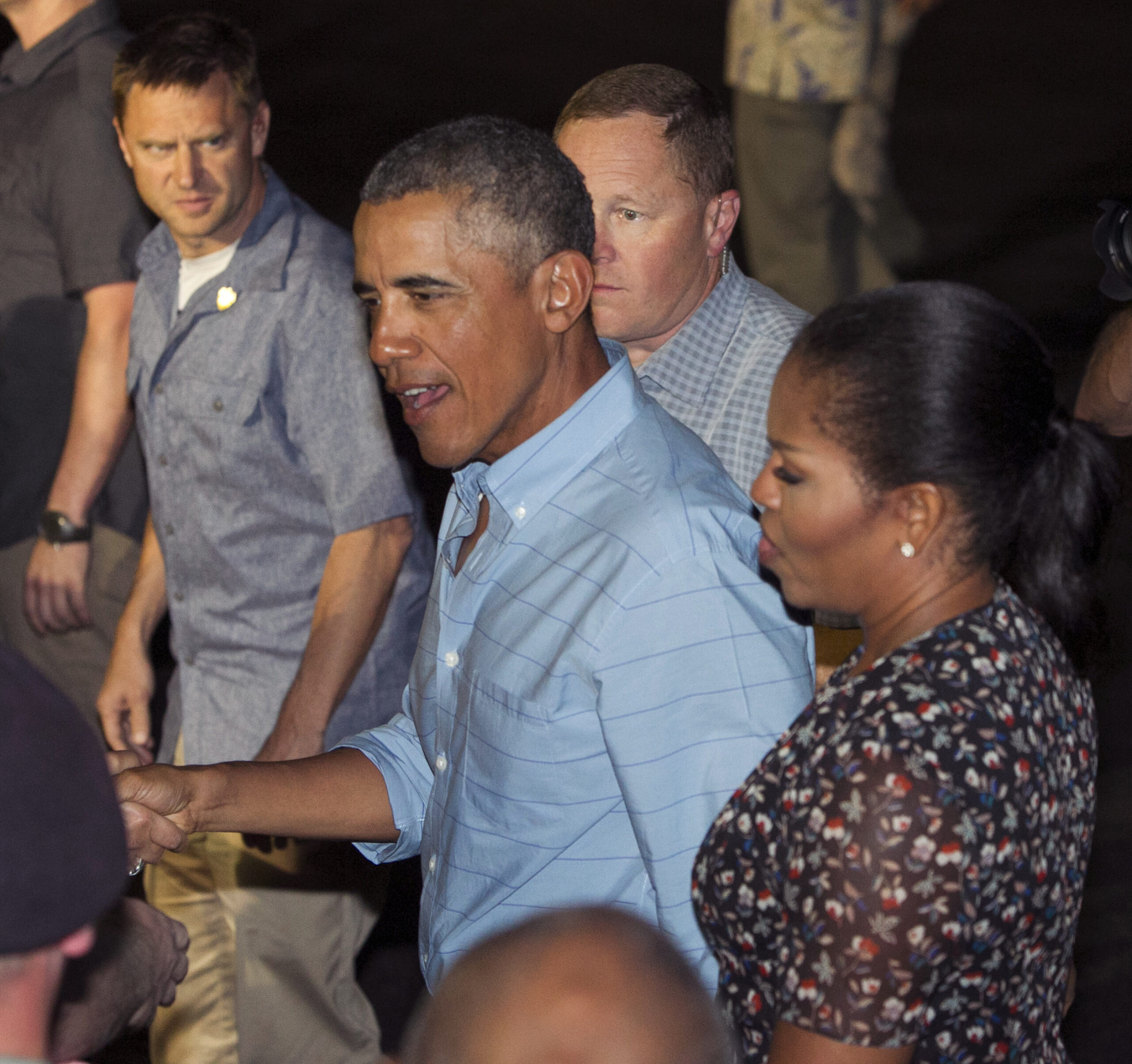 U.S. President Barack Obama and first lady Michelle Obama greet people before boarding Air Force One as they leave Joint Base Pearl Harbor-Hickam, adjacent to Honolulu, Hawaii, en route to Washington, Sunday, Jan. 1, 2017, after their annual family vacation on the island of Oahu. (AP Photo/Marco Garcia) (AP)