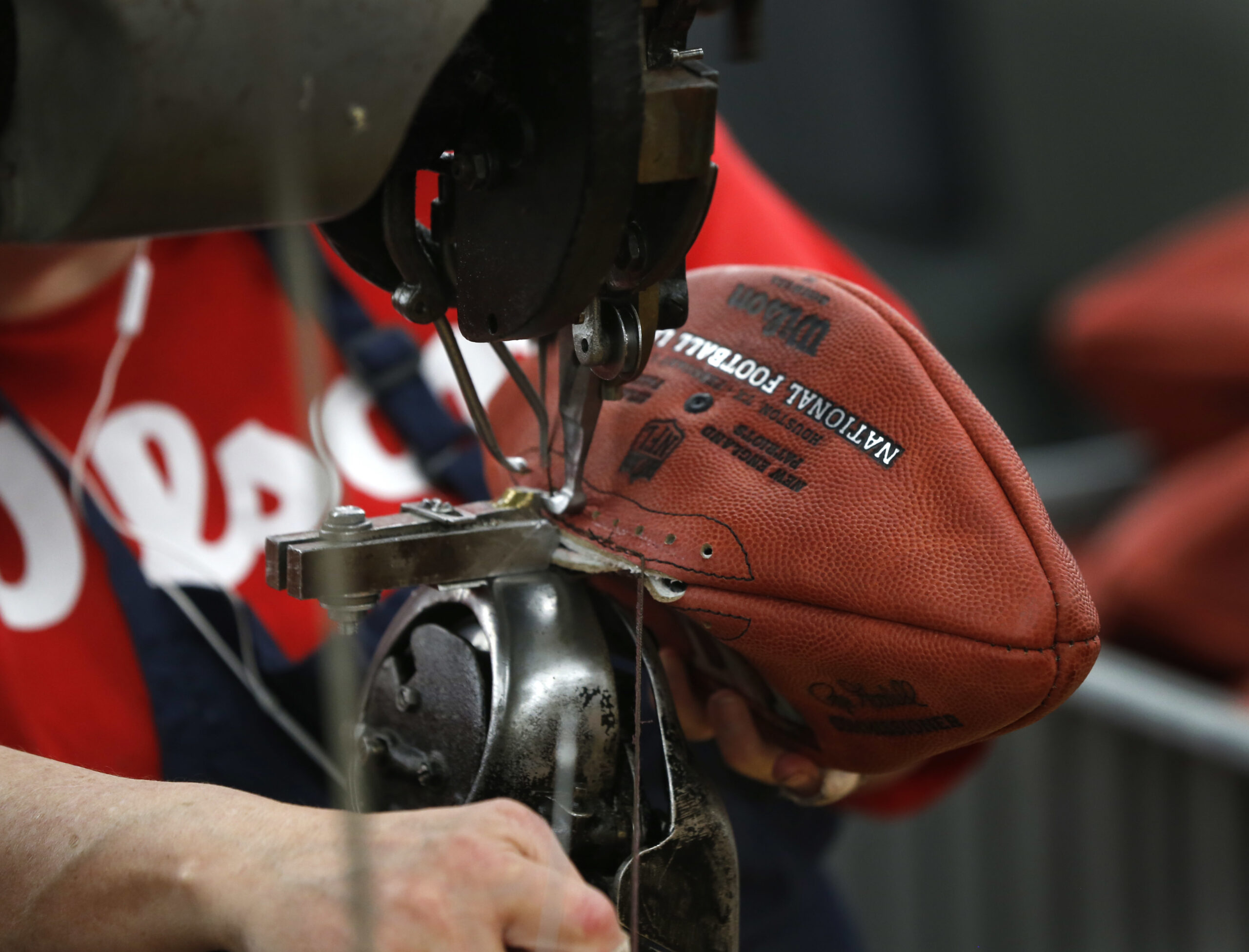 In this Monday, Jan. 23, 2017, photo an NFL Super Bowl LI football is sewn at the Wilson Sporting Goods factory in Ada, Ohio. Plant workers use turn-of-last-century sewing machines and other vintage equipment to make about 3,000 footballs per day, cutting, stitching and lacing each by hand. The 25-step process takes about three days to complete, but the pride in craftsmanship is evident in those who work there. (AP Photo/Charles Rex Arbogast) (AP)