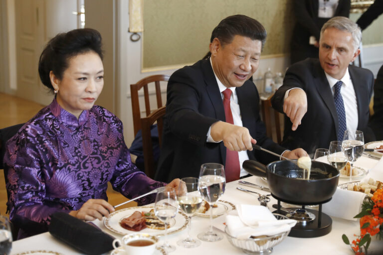 China's President Xi Jinping, center, Xi's wife Peng Liyuan, left, and Swiss Foreign Minister Didier Burkhalter eat Swiss cheese fondue during lunch during Xi's two days state visit to Switzerland in Bern, Switzerland, Monday, Jan. 16, 2017.  (Peter Klaunzer/Pool Photo via AP) (AP)