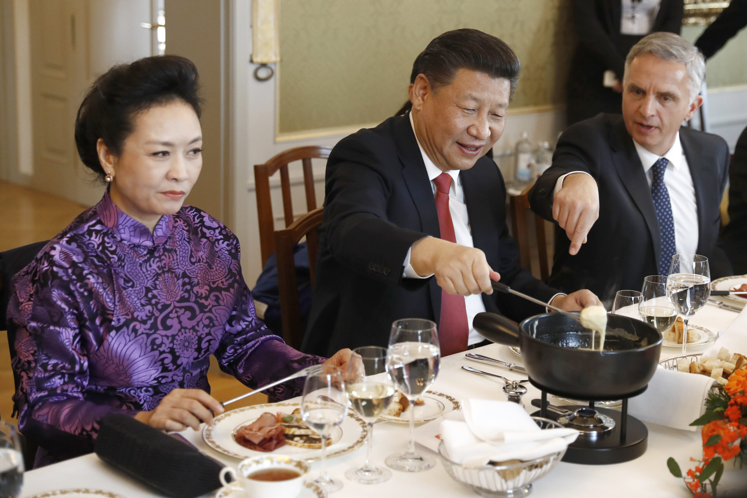 China's President Xi Jinping, center, Xi's wife Peng Liyuan, left, and Swiss Foreign Minister Didier Burkhalter eat Swiss cheese fondue during lunch during Xi's two days state visit to Switzerland in Bern, Switzerland, Monday, Jan. 16, 2017.  (Peter Klaunzer/Pool Photo via AP) (AP)