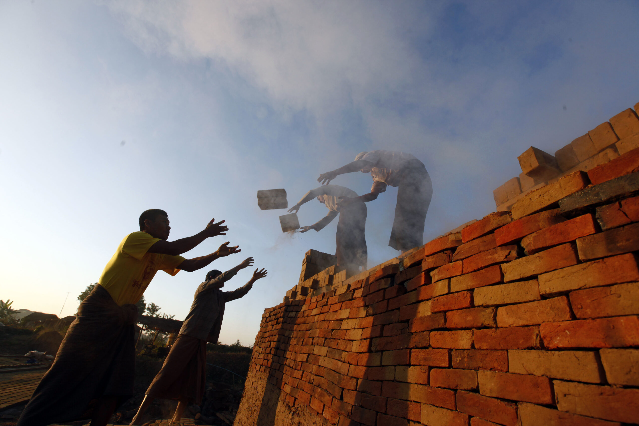 In this Friday, Jan. 13, 2017 photo, workers unload bricks at a brick-making factory in Naypyitaw, Myanmar. As bricks continue to be used in construction throughout Myanmar, traditional craftsmen who produce hand-made bricks are facing competition from machine-made bricks which are produced more efficiently. (AP Photo/Aung Shine Oo, File) (AP)