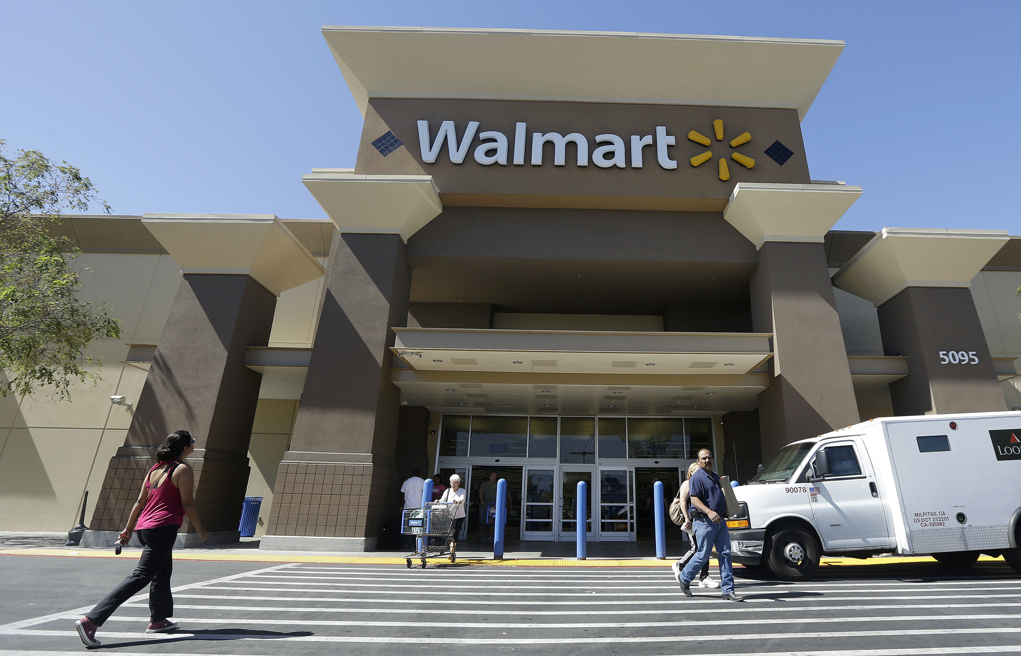 FILE - In this Sept. 19, 2013, file photo, customers walk outside of a Wal-Mart store in San Jose, Calif. From Wal-Mart to General Motors to Amazon, a growing number of the world’s largest companies appear to be trying to get in step with President-elect Donald Trump’s demand that employers hire and keep jobs at home. (AP Photo/Jeff Chiu, File) (AP)