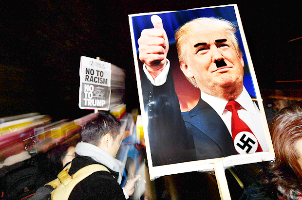 A demonstrator holds a sign during a protest outside the US Embassy in London, November 9, 2016. (Getty/Ben Stansall)