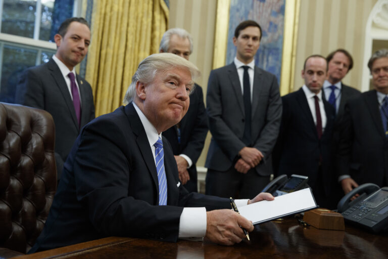 President Donald Trump looks up after signing the final of three executive orders, Monday, Jan. 23, 2017, in the Oval Office of the White House in Washington. (AP Photo/Evan Vucci) (AP/Evan Vucci)