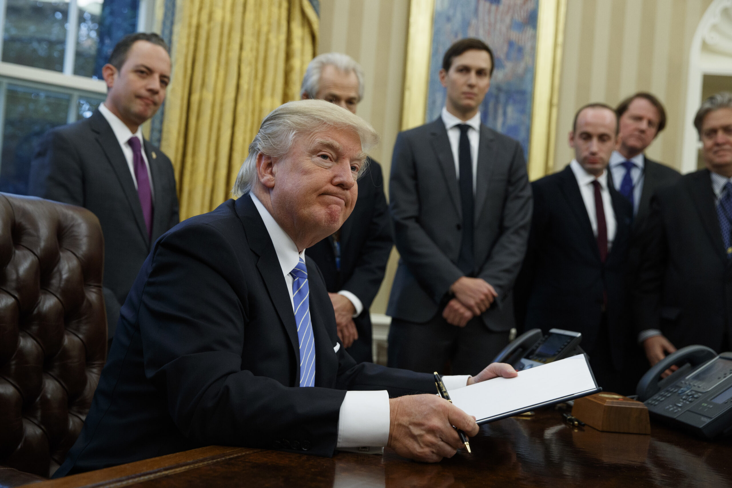 President Donald Trump looks up after signing the final of three executive orders, Monday, Jan. 23, 2017, in the Oval Office of the White House in Washington. (AP Photo/Evan Vucci) (AP/Evan Vucci)