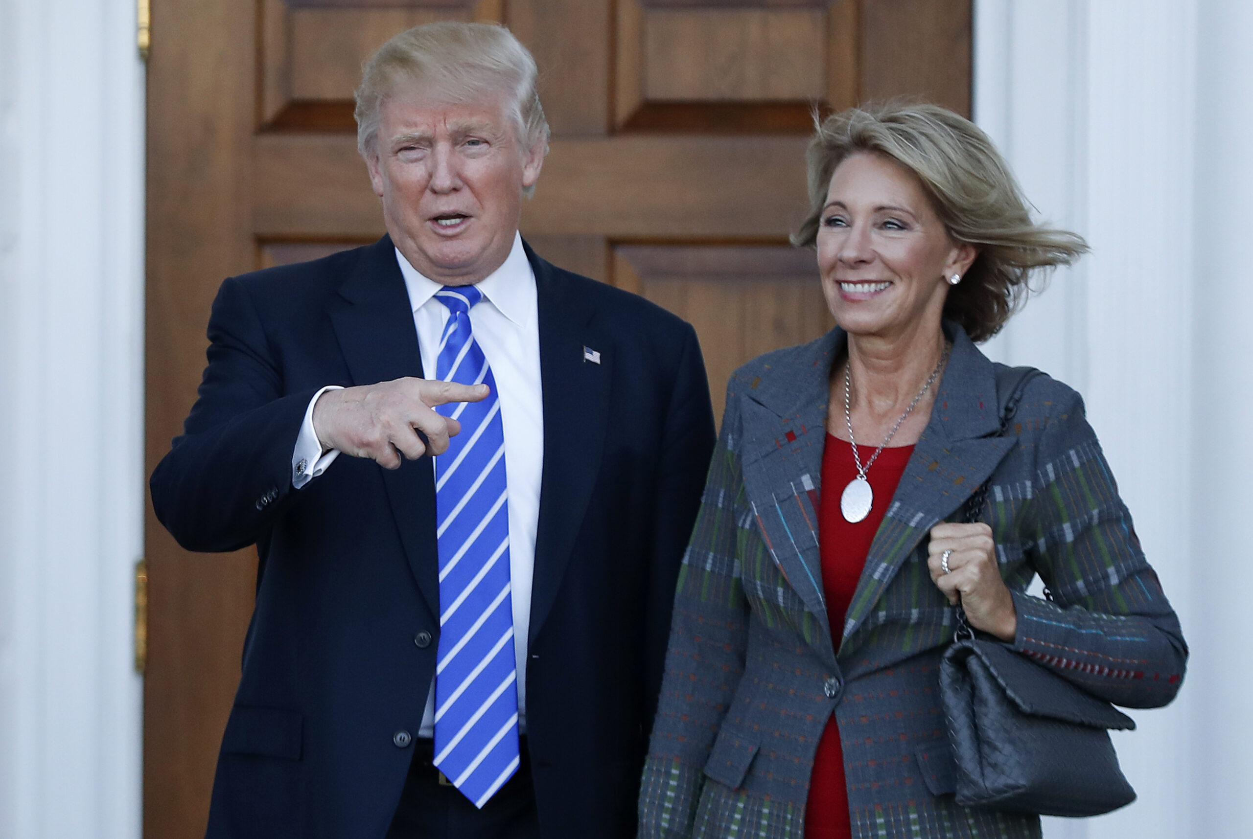 FILE - In this Nov. 19, 2016 file photo, President-elect Donald Trump stands with Education Secretary-designate Betsy DeVos in Bedminster, N.J.  DeVos has spent over two decades advocating for school choice programs, which give students and parents an alternative to traditional public school education. Her confirmation hearing was scheduled for Jan. 17. (AP Photo/Carolyn Kaster, File) (AP Photo/Carolyn Kaster)