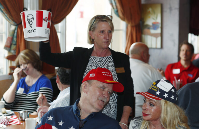 Sue Moore holds up an empty chicken bucket as she asks for donations from local Republicans as they gather to watch the inauguration of Donald Trump as president of the United States at a Greek restaurant on Friday, Jan. 20, 2017, in east Denver. (AP Photo/David Zalubowski) (AP)