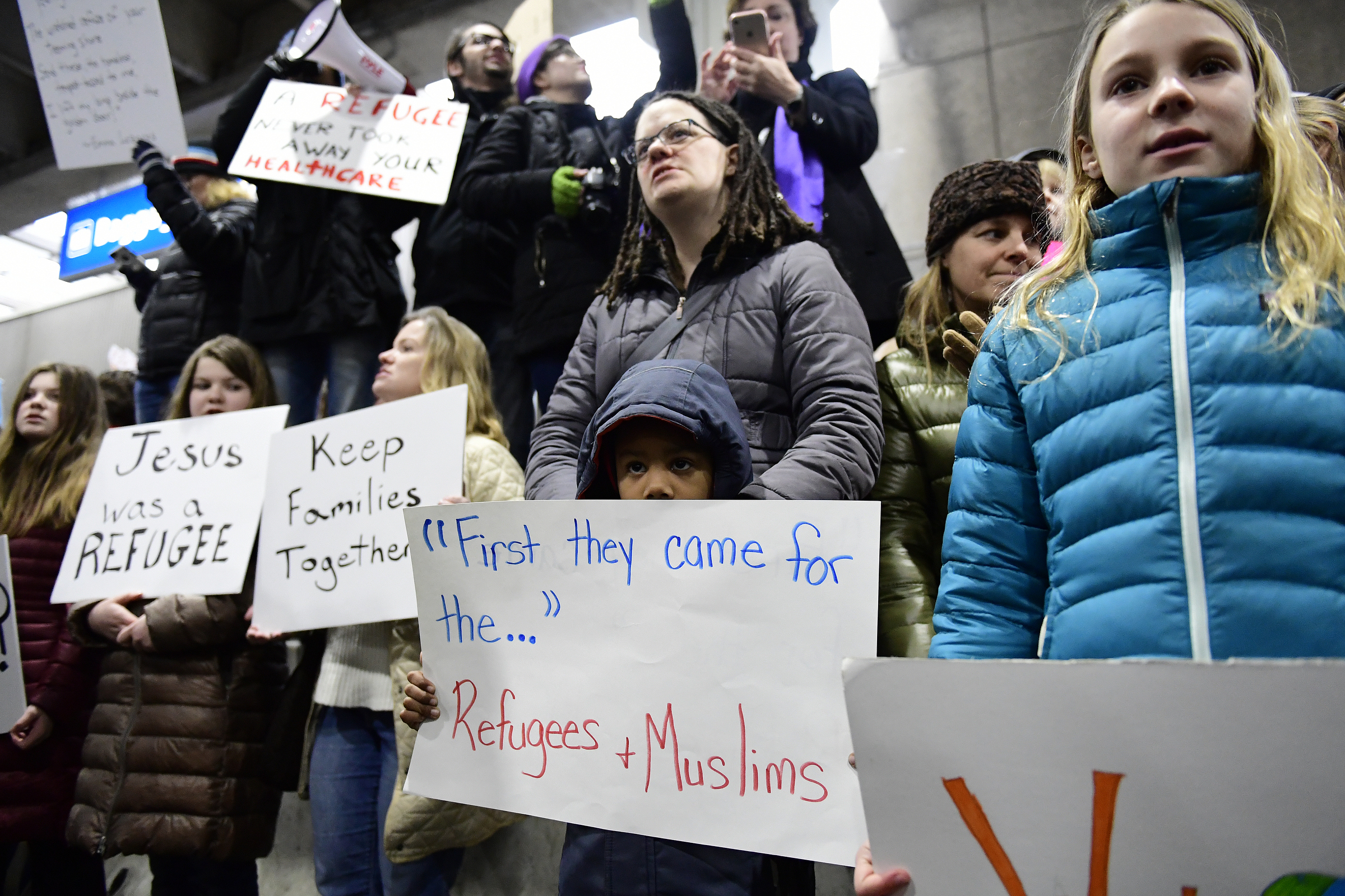 Stephanie Hartley-Bah and her son Jah'kier Hartley, 7, both of Bear, Del., listen during a protest of President Donald Trump's travel ban on refugees and citizens of seven Muslim-majority nations, Sunday, Jan. 29, 2017, at Philadelphia International Airport in Philadelphia. (AP Photo/Corey Perrine) (AP)