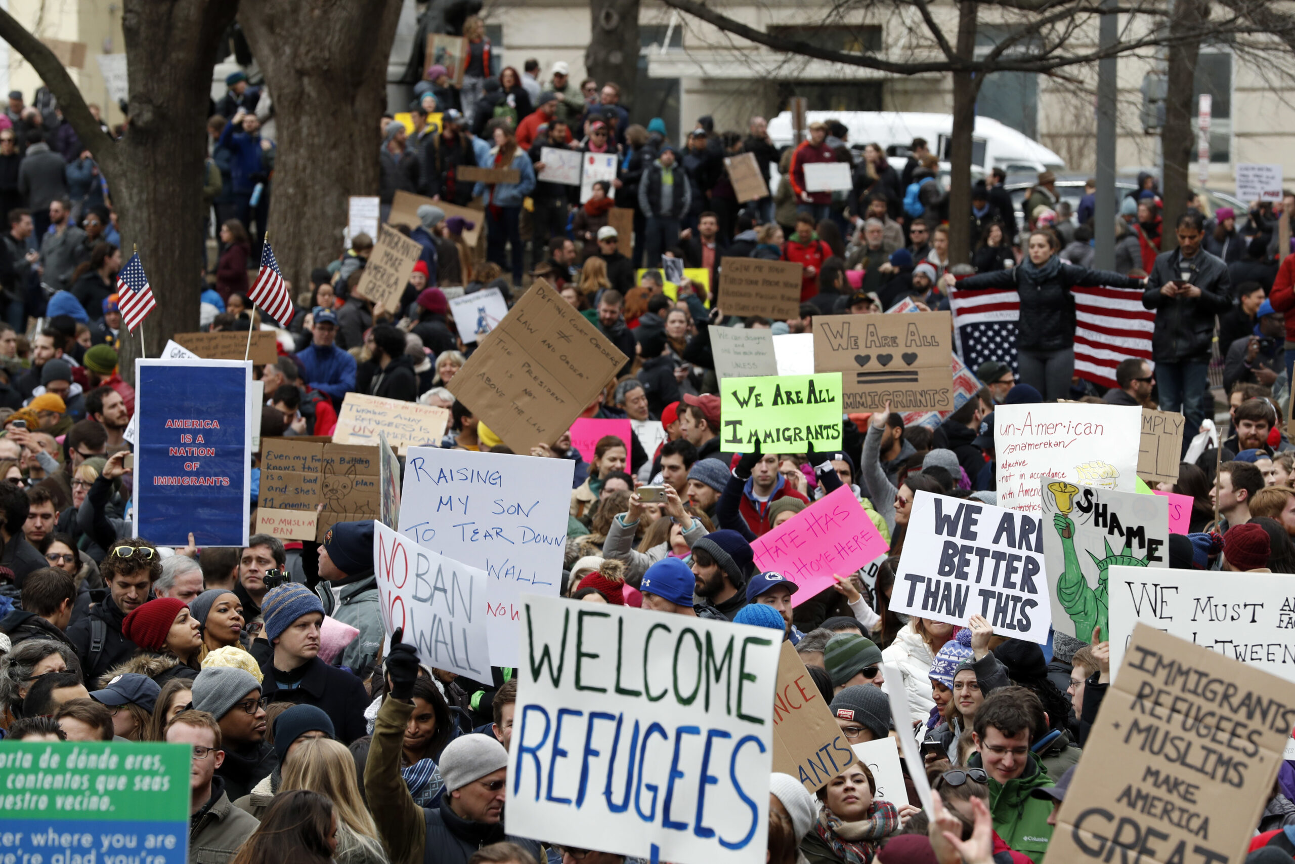 Protesters carry signs and chant in Lafayette Park near the White House during a demonstration to denounce President Donald Trump's executive order that bars citizens of seven predominantly Muslim-majority countries from entering the U.S. on Sunday, Jan. 29, 2017, in Washington. (AP Photo/Alex Brandon) (AP)