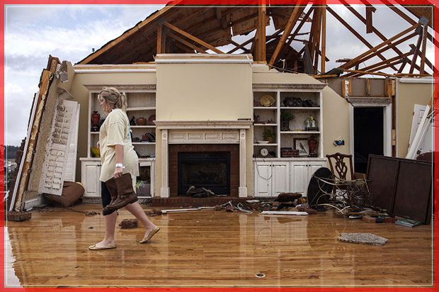 Jenny Bullard carries a pair of boots from her home that was damaged by a tornado, Sunday, Jan. 22, 2017, in Adel, Ga. Georgia Gov. Nathan Deal declared a state of emergency in several counties, including Cook, that have suffered deaths, injuries and severe damage from weekend storms. (AP Photo/Branden Camp) (AP)