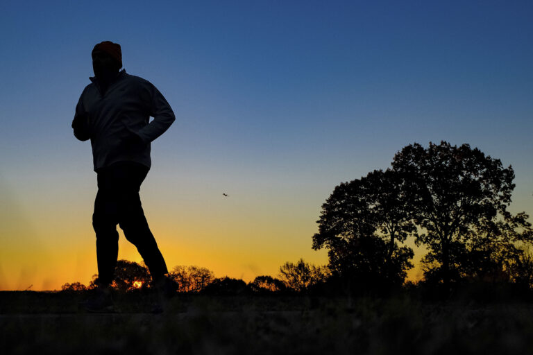 FILE - In this Tuesday, Nov. 22, 2016 file photo, a runner is silhouetted against the sunrise on his early morning workout near Arlington National Cemetery in Arlington, Va., across the Potomac River from the nation's capital. Research released on Monday, Jan. 9, 2017 suggests that people who pack their workouts into one or two days a week lower their risk of dying as much as those who exercise more often, as long as they get enough of it. (AP Photo/J. David Ake) (AP)