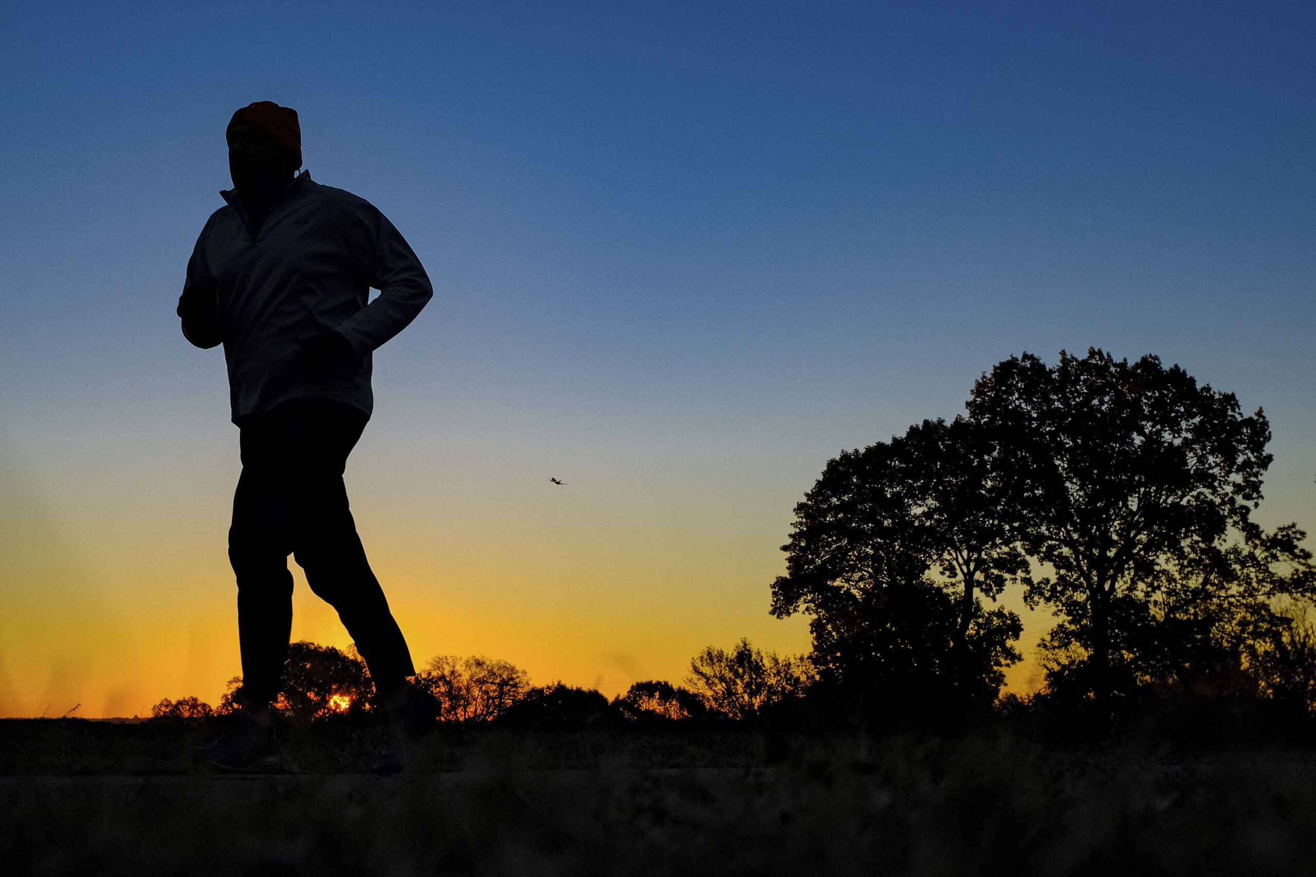 FILE - In this Tuesday, Nov. 22, 2016 file photo, a runner is silhouetted against the sunrise on his early morning workout near Arlington National Cemetery in Arlington, Va., across the Potomac River from the nation's capital. Research released on Monday, Jan. 9, 2017 suggests that people who pack their workouts into one or two days a week lower their risk of dying as much as those who exercise more often, as long as they get enough of it. (AP Photo/J. David Ake) (AP)