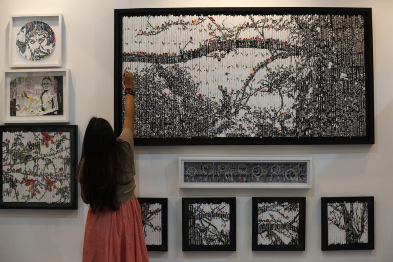 Vinila Dasgupta retouches her art during India Art Fair in New Delhi, India, Thursday, Feb. 2, 2017. The four day art fair brings together a number of modern and contemporary artists to present their works. ( (AP Photo/Tsering Topgyal))
